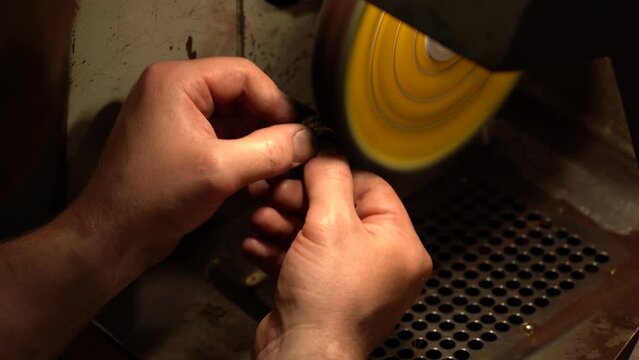 Different goldsmiths tools on the jewelry workplace. Jeweler at work in jewelry. Lapidary worker polishing boulder precious stone or metal. no face, unrecognizable person.