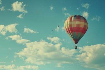 Naklejka premium Colorful hot air balloon floats in a clear sky with fluffy clouds, portraying peaceful travel