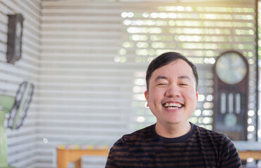 cute asian man feeling happy and smile in vacation day, he has canine teeth, he show funny face and...