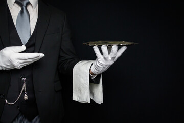 Portrait of Butler or Waiter in Dark Suit and White Gloves Holding Serving Tray. Professional Courtesy and Service Industry.