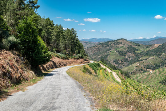 Estrada sinuosa entre montes e montanhas sob um c&eacute;u azul