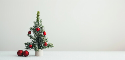 Small decorated Christmas tree with red baubles. Christmas break. Christmas break.