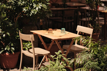 Cosy Restaurant Interior With Wooden Table And Chairs With Empty Shiny Glasses