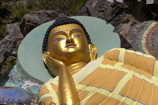 image of a Buddhist figure, thoughtful, dressed in colors, in the garden of the Buddhist temple of Panillo, Spain