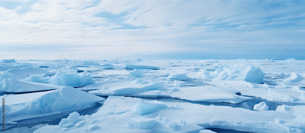 Aufkleber Massive ice formations float in the ocean against a cloudy sky, while the Arctic white pancake ice structure reveals itself in the blue sea. with copy space image. Place for adding text or design