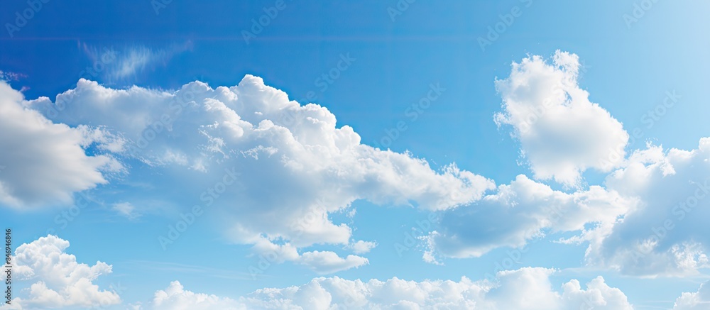 Poster Kids having fun flying a vibrant kite on the sandy beach with a clear blue sky and fluffy clouds. with copy space image. Place for adding text or design
