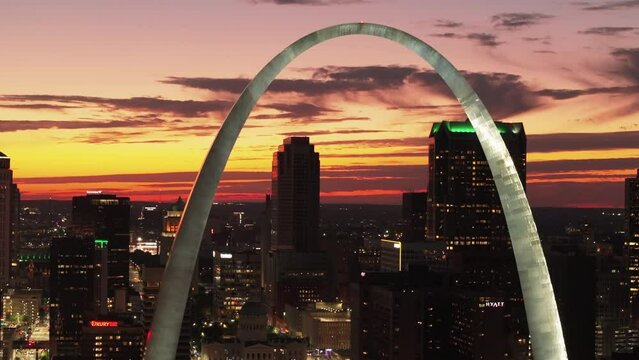 Majestic St. Louis arch at sunset, basking in a warm glow against the vibrant cityscape backdrop. A mesmerizing view of this iconic landmark