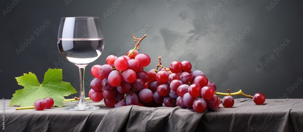 Aufkleber Glass of red wine with a bunch of grapes on a rustic wooden table, creating a simple yet elegant setup. with copy space image. Place for adding text or design