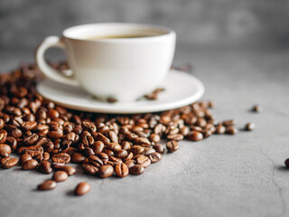 Close up of backdrop dark brown coffee beans and coffee cup background.