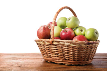 Fresh red and green apples in wicker basket on wooden table against white background. Space for text