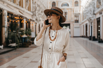 attractive woman walking in shopping street in Italy on vacation dressed in white summer fashion dress