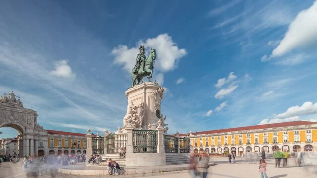 Praca do Comercio (Commerce Plaza). Statue of King Jose I timelapse hyperlapse. The king is symbolically crushing snakes on his path. Cloudy sky and colorful houses on a background. Lisbon, Portugal.