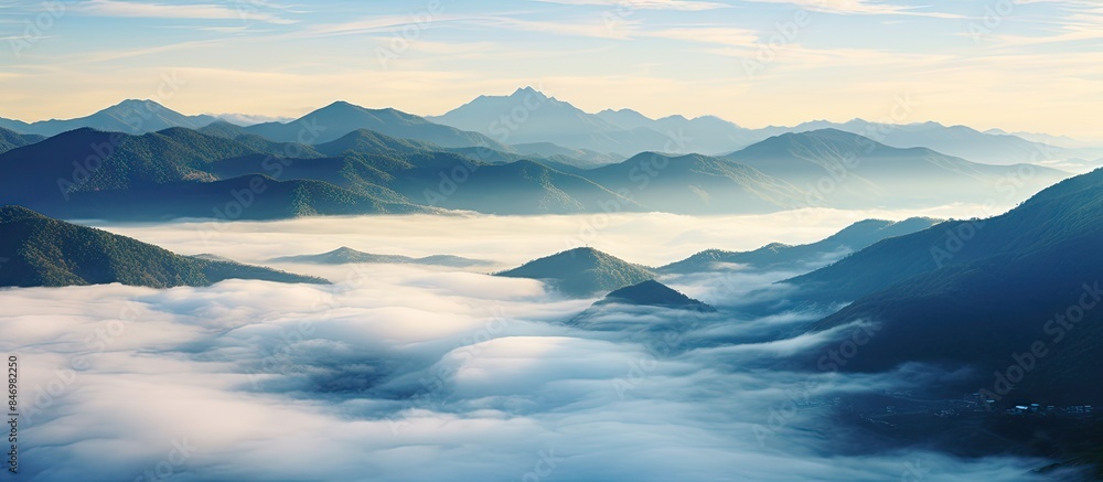 Aufkleber Scenic view of mountains covered in clouds, with a sea of clouds below and low-lying clouds in the distance. with copy space image. Place for adding text or design