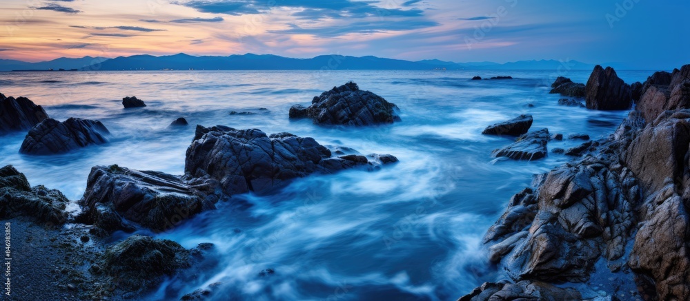 Poster Ocean view with rocks and waves under the colorful sky during sunset. with copy space image. Place for adding text or design