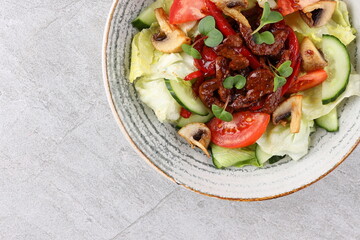 Asian beef salad with vegetables and nuts in a white bowl on a dark background. Asian food concept.