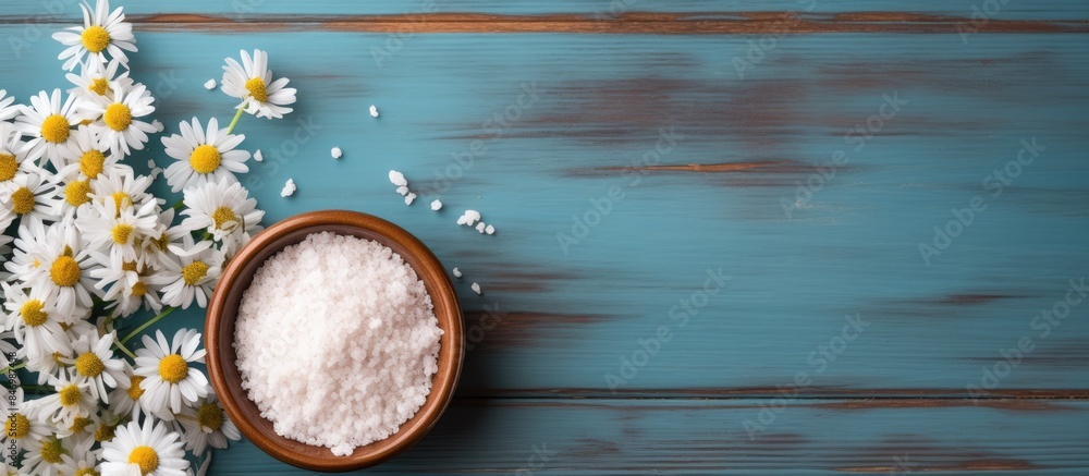 Aufkleber Sea salt scattered around delicate daisies on a textured brown surface, creating a simple and serene composition. with copy space image. Place for adding text or design