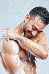 Naklejka premium Cosmetics, man and washing body for hygiene, grooming and self care or cleaning in studio grey background. Wellness, male person and water with soap showering for physical health and exfoliation