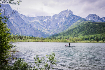 A beautiful view on the Ehrwalder Almsee and the Zugspitze on a sunny summer day in Austria, 2024, pescadores, haciendo su labor del dia para llevar comida a casa