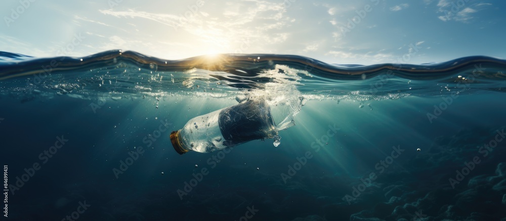Poster Bottle floating in the ocean with sunlight shining through, depicting plastic pollution and harm to nature. with copy space image. Place for adding text or design
