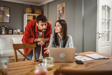 Obraz premium Woman work from home on laptop while boyfriend help and support her