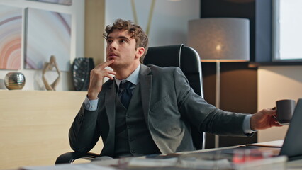 Dreaming worker enjoying coffee break at desk closeup. Pensive manager resting