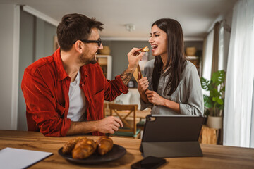 Couple eat croissant together enjoy before work day at home