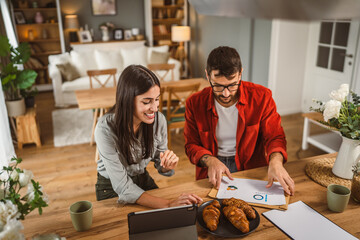 Couple prepare documents for work have coffee and breakfast at home