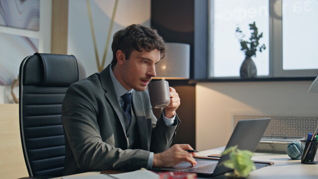 Multitasking businessman sipping coffee at office closeup. Boss writing notes