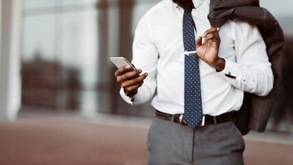 Afro Businessman Sending Messages Via Mobile Phone, Having Lunch Break and Walking Outdoors
