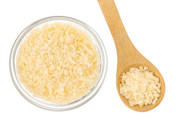 grated parmesan cheese in glass bowl and wooden spoon isolated on white background. Top view. Flat lay