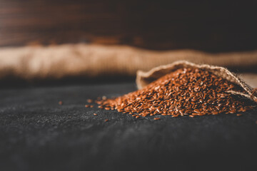 Flax seeds spill out of a burlap bag