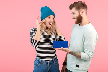 young attractive couple listening to music on wireless speaker