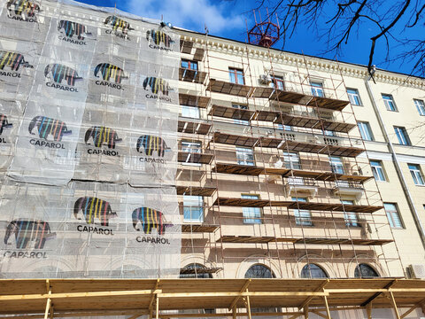 Minsk, Belarus. Mar 16, 2024. Historical building covered in scaffolding and Caparol mesh for reconstruction and renovation works, preservation efforts. Historical building with scaffolding
