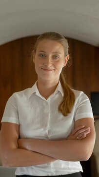 Businesslady smiling while travelling on private jet - Portrait of business woman taking a first class flight for work. Daylight from portholes. Slow motion Vertical shot.