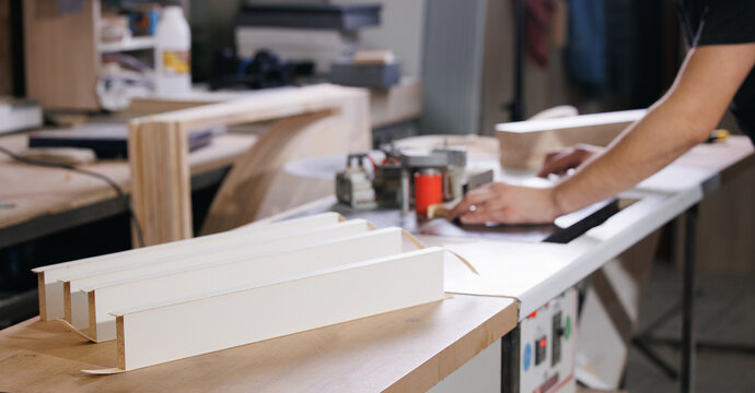 Process Gluing edge on machine to chipboard laminate board for production furniture in wooden carpentry