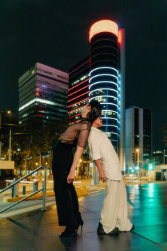 Leaning agains eachother between city lights