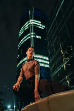 Model in black bold clothes crouching 