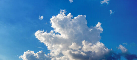 A white curly cloud of a strange shape in a blue sky in sunny weather © Volodymyr