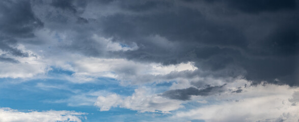 A dark storm cloud hangs over the blue sky