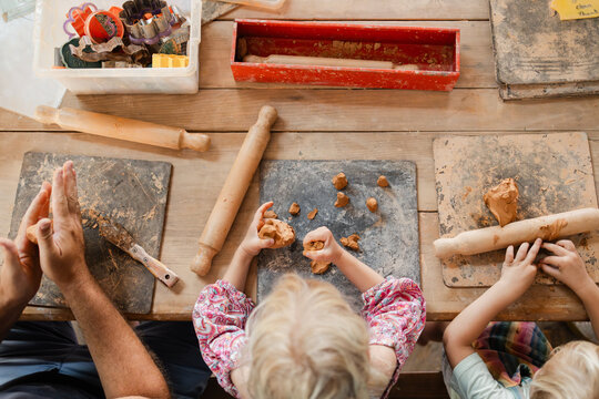 Father and children working with clay - Powered by Adobe