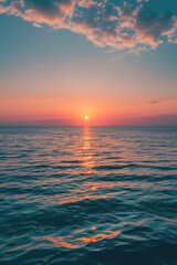 Obraz premium A serene scene of sunset over the ocean on a cloudy day, ideal for travel or nature-related themes