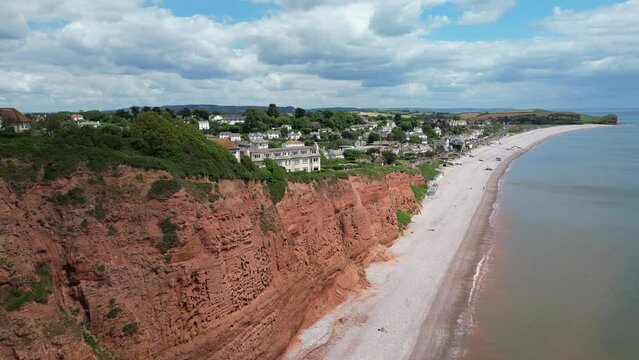 Budleigh Salterton, East Devon, England: DRONE VIEWS: The drone rises over Jurassic Coast red sandstone cliffs to reveal the town of Budleigh Salterton, a popular English holiday destination (2).
