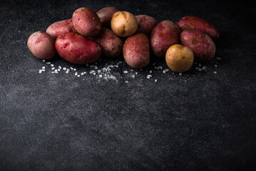 Raw uncooked potato on dark table
