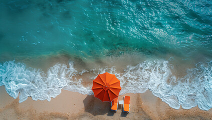 Obraz premium orange beach umbrella and loungers on the sandy seashore with waves, top view, sunlight, photo from drone.