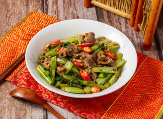 Shacha Lamb with vegetables, chopsticks and spoon served in dish isolated on napkin side view on wooden table of taiwanese food