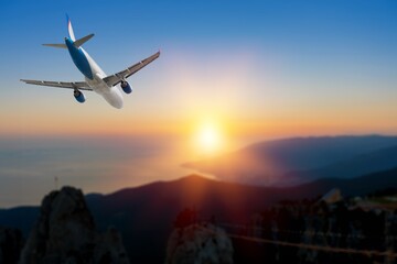Airplane flight in colored sunset sky
