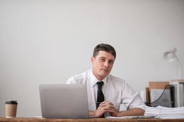 Young Businessman Sitting at Desk Looking Disappointed and Frustrated at Work in Modern Office Environment