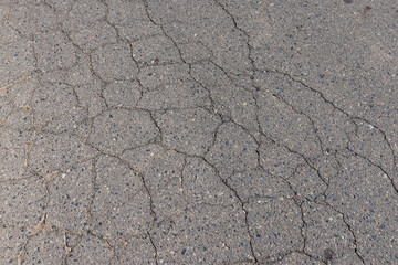 a part of a highway covered with cracked asphalt