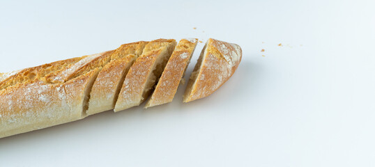 Loaf of fresh bread cut into slices. White background with copy space.