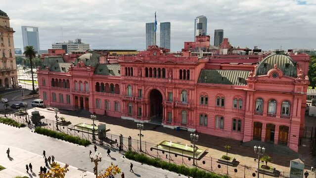 Facade of the government house Casa Rosada. Aerial camera moving back and up revealing Puerto Madero in the background